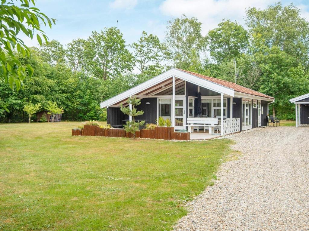 ein schwarzes Haus mit einem großen Hof in der Unterkunft Holiday home Oksbøl LXXXIV in Oksbøl