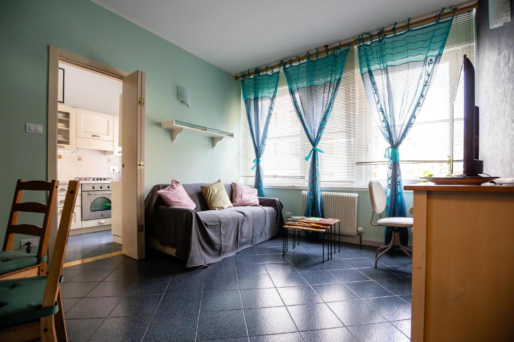 een woonkamer met een bank en een raam bij Severo Cento in Trieste