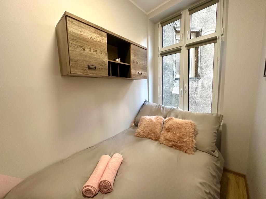 un sofá en una habitación con 2 almohadas en MMRent Rose Room en Gdansk