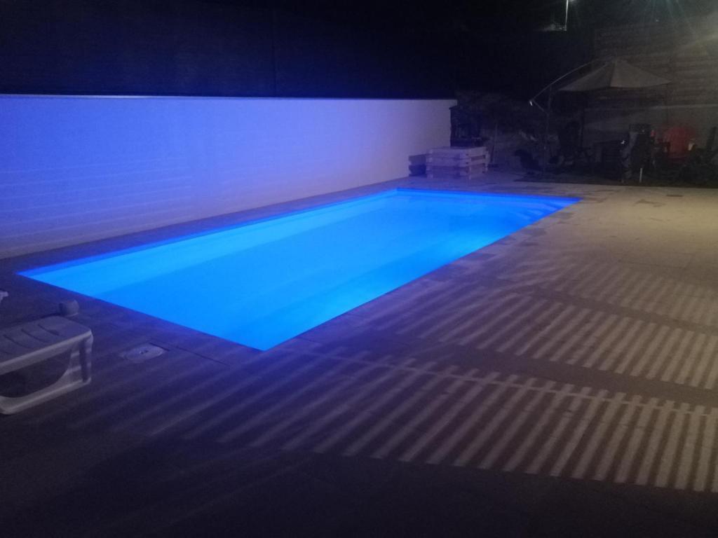 a large swimming pool with blue lighting in a dark room at Villa Harmony in Bihać