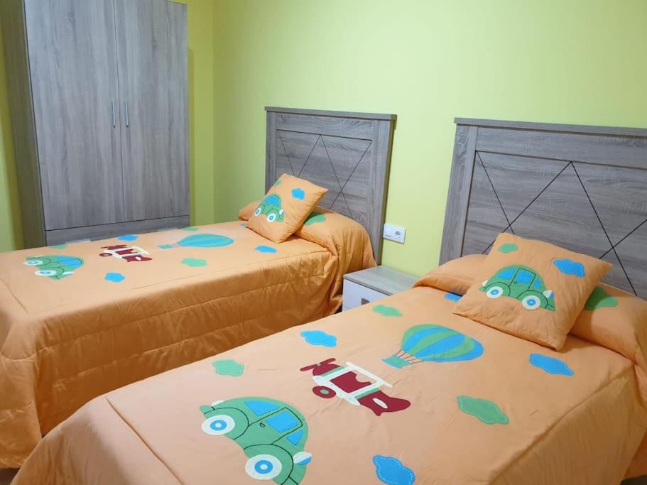 1 dormitorio con 2 camas con carros de juguete en Acogedor alojamiento cercano a las termas, en Ourense