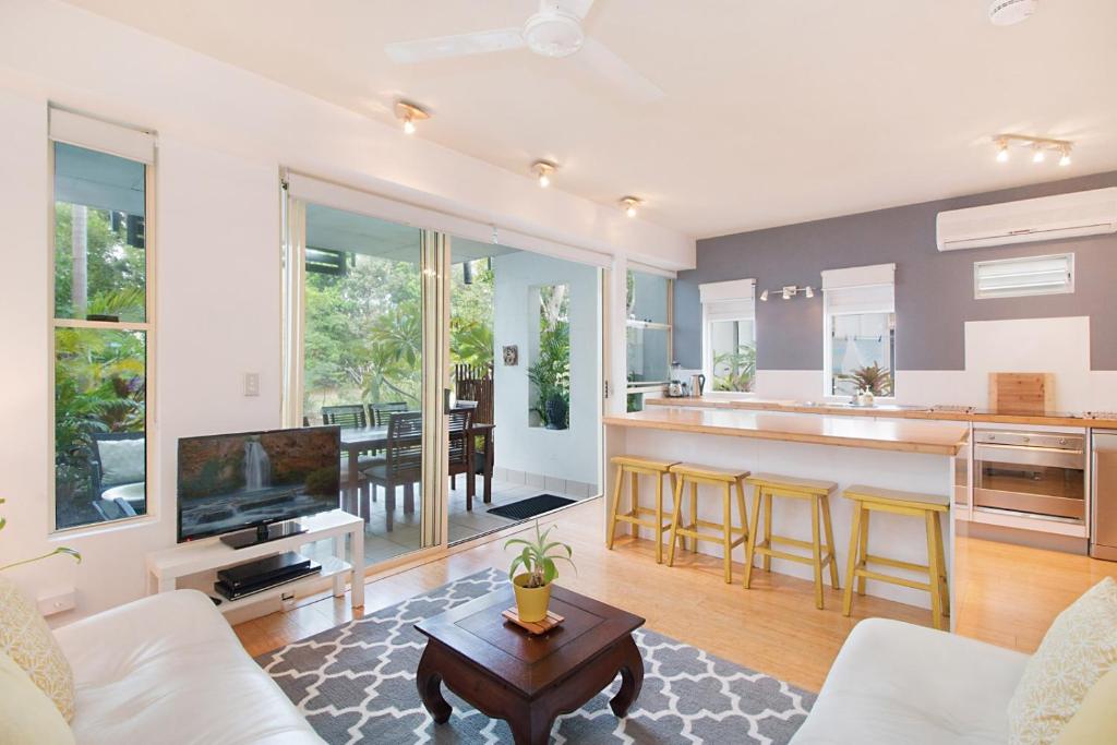 Short Stroll to White Sandy Beach في ساحة كاسوارينا: غرفة معيشة مع أريكة وطاولة ومطبخ