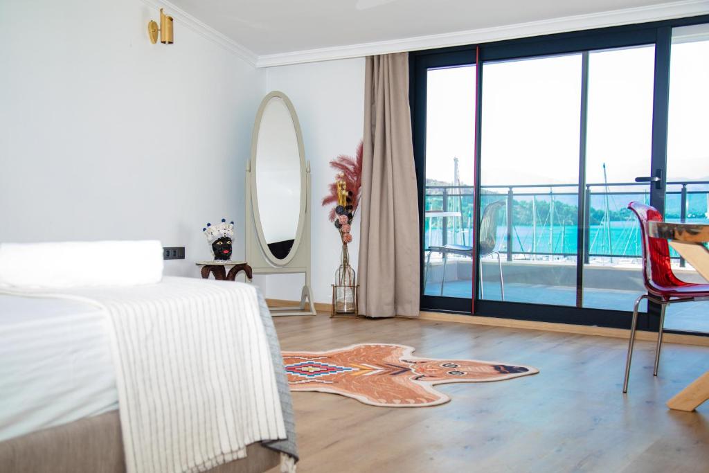 a bedroom with a bed and a floor to ceiling window at Körfez Suites in Fethiye