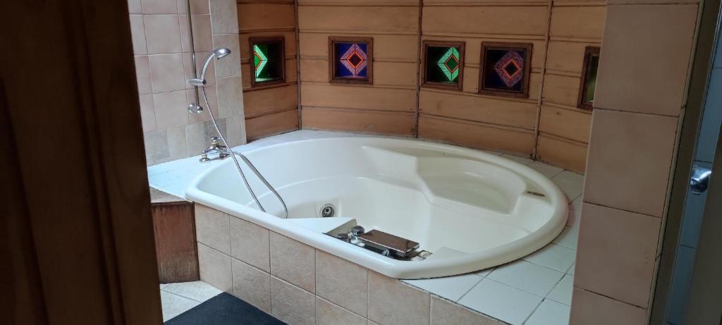 a large bath tub in a bathroom with a tile floor at CASA PENSION PUERTA DEL SOL in Puerto Montt