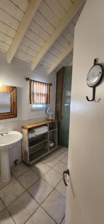 a bathroom with a sink and a toilet and a door at Casa Tenis Hotel & Club in Benavídez
