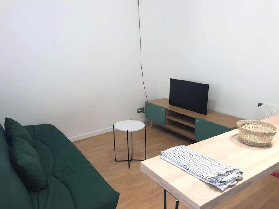 - un salon avec un canapé vert et une table dans l'établissement Studio confortable près de paris, à Villejuif