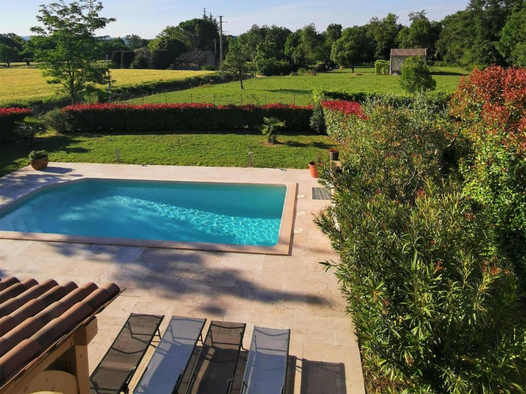 una piscina en un patio junto a un jardín en Marguerite, en Callian