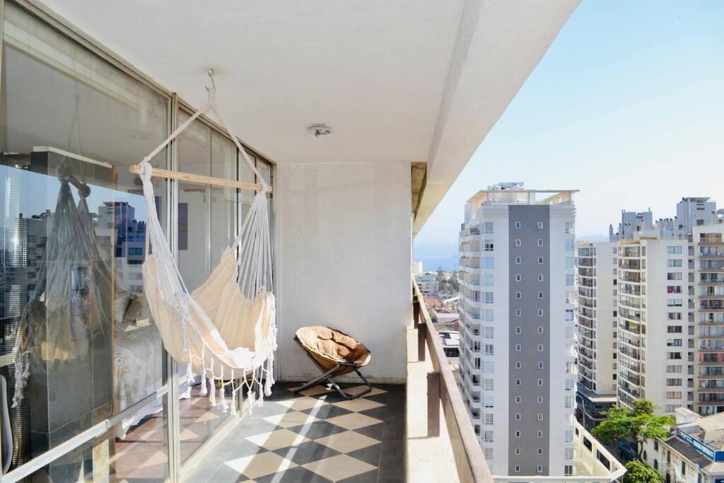 a balcony with a hammock and a view of a city at Departamento muy central, a pasos de playa, bares y terminal in Viña del Mar