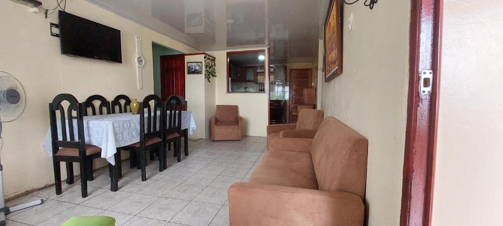 a living room with a couch and a table and chairs at HOSTEL CASA MARINA in Puerto Limón