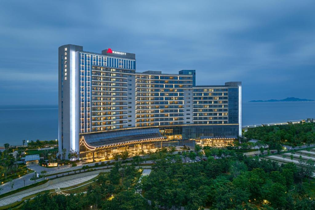 um grande edifício com luzes acesas numa cidade em Yantai Marriott Hotel em Yantai