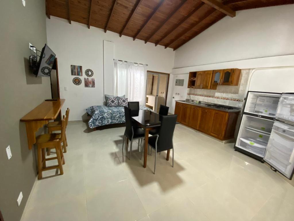 cocina y sala de estar con mesa y sillas en ApartaHotel Los Naranjos, en Apartadó