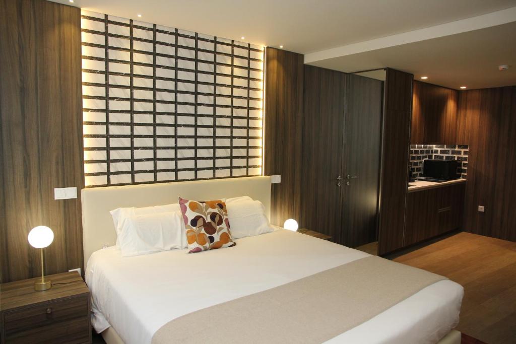 um quarto com uma grande cama branca e uma janela em BrandApartments no Porto