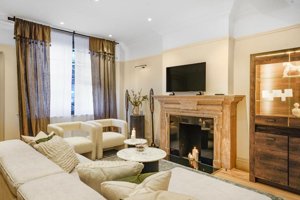 a living room with a fireplace and a tv at Spacious and Modern 4 beds home in Kensington in London