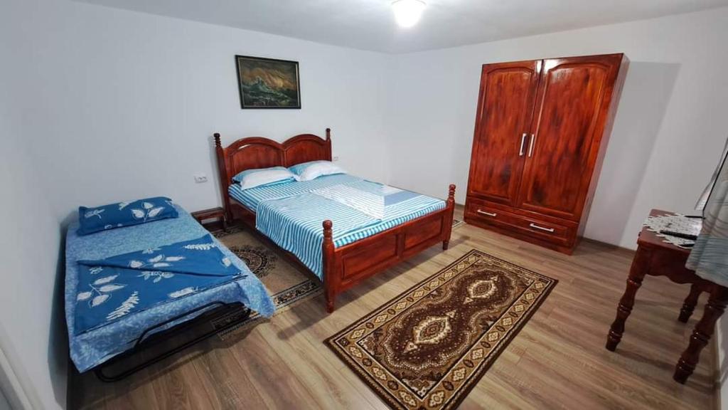 a bedroom with two beds and a dresser and a table at Pensiunea Casa Golovita in Jurilovca