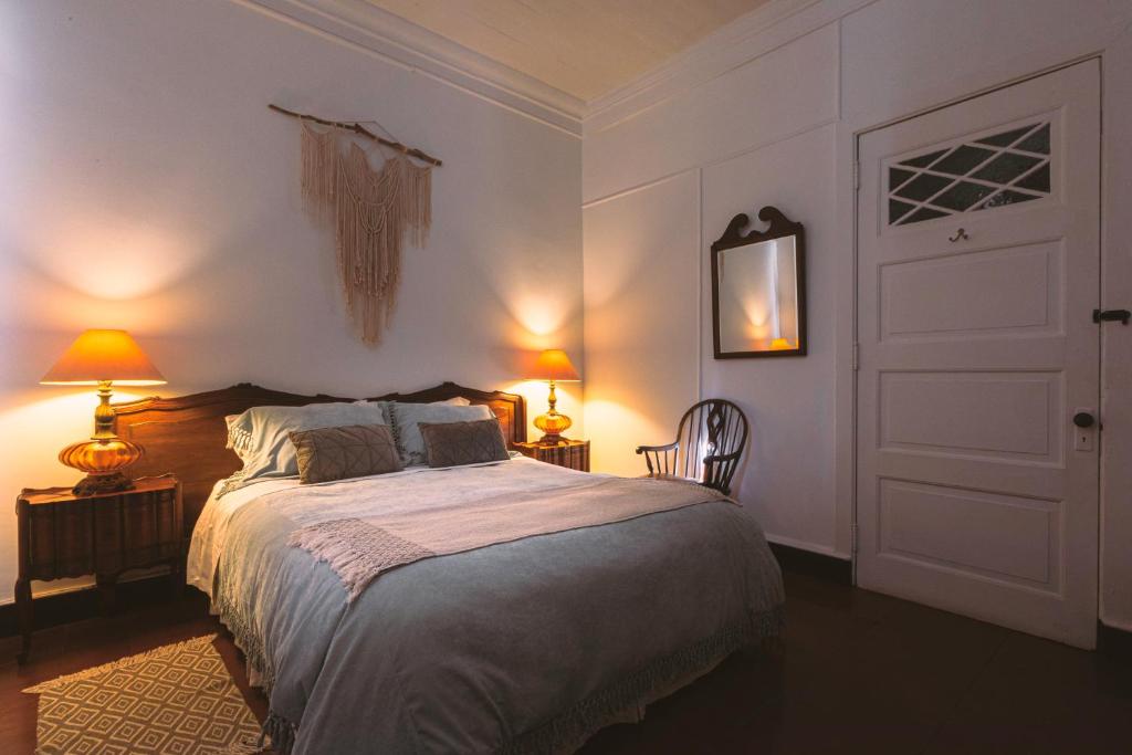 a bedroom with a bed and two lamps and a door at Casona El Resguardo - Solo Adultos in Río Blanco