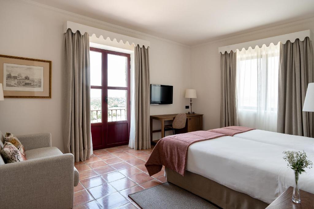 Una habitación de hotel con una cama grande y una ventana. en Parador de Ciudad Rodrigo, en Ciudad Rodrigo