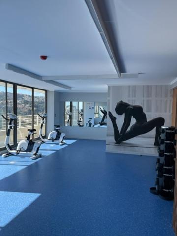 una sala de fitness con una mujer haciendo una pose de yoga en un gimnasio en Apartamento nuevo en Centro de Viña del Mar, Parque Urbano, en Viña del Mar