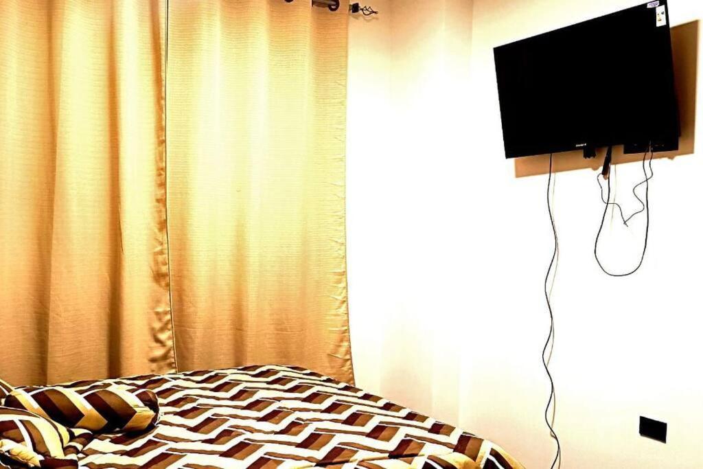 1 dormitorio con 1 cama y TV de pantalla plana en Departamento Cochabamba en Cochabamba
