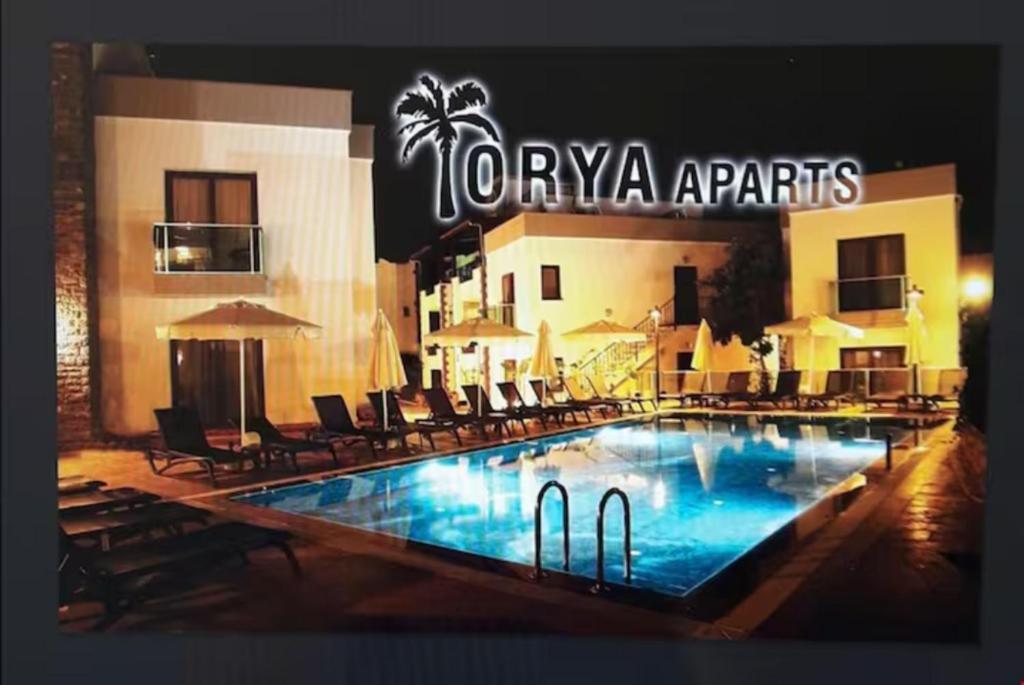 a hotel with a swimming pool in front of a building at Orya Aparts in Gümbet