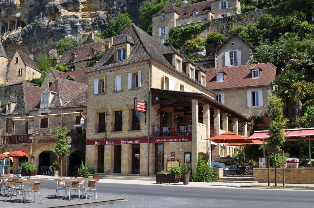 budynek po stronie ulicy ze stołami i krzesłami w obiekcie Auberge des Platanes w mieście La Roque-Gageac