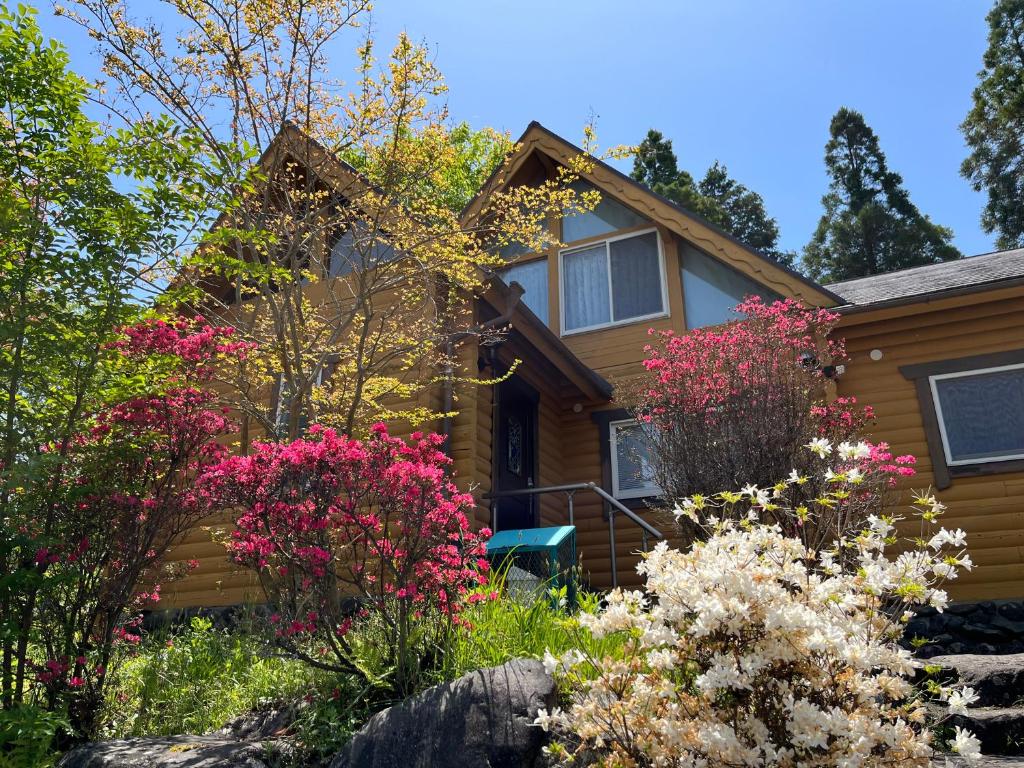 a house with flowers in front of it at Kurokawa Marigold in Minamioguni