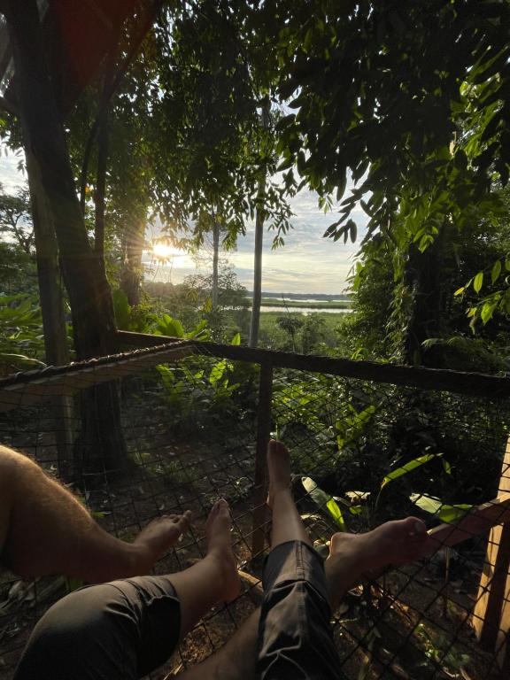 a person laying on the ground with their feet up in the trees at Konsenda Bocas del Toro in Bocas del Toro