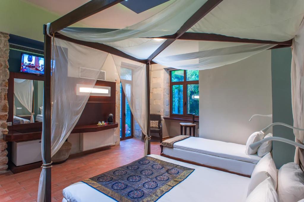 1 Schlafzimmer mit 2 Betten und einem Himmelbett in der Unterkunft Splanzia Boutique Hotel in Chania