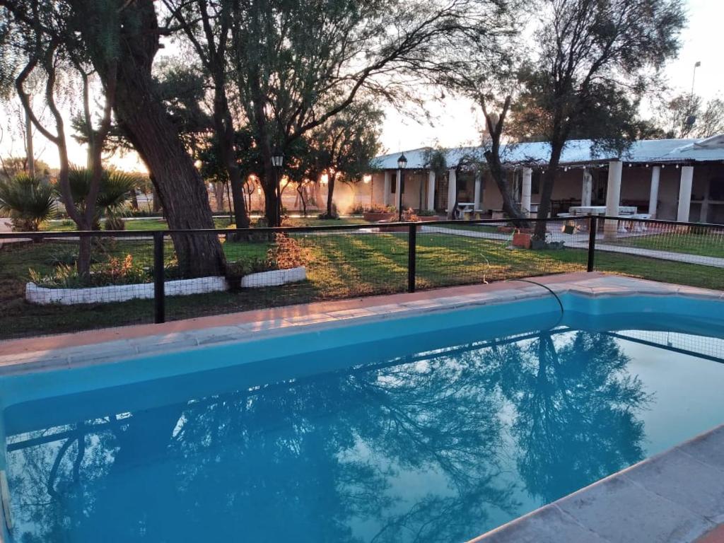 a swimming pool in front of a house with trees at Mama Maruja in San Luis