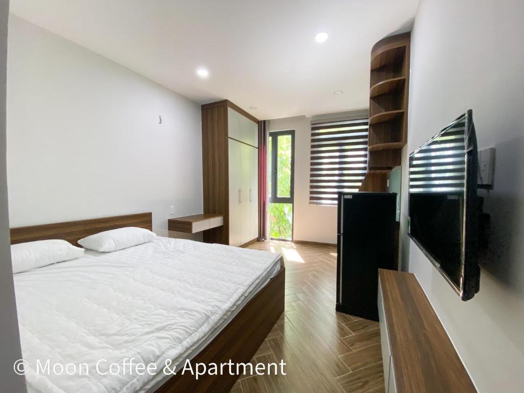 a bedroom with a bed and a flat screen tv at Moon Apartment in Ho Chi Minh City