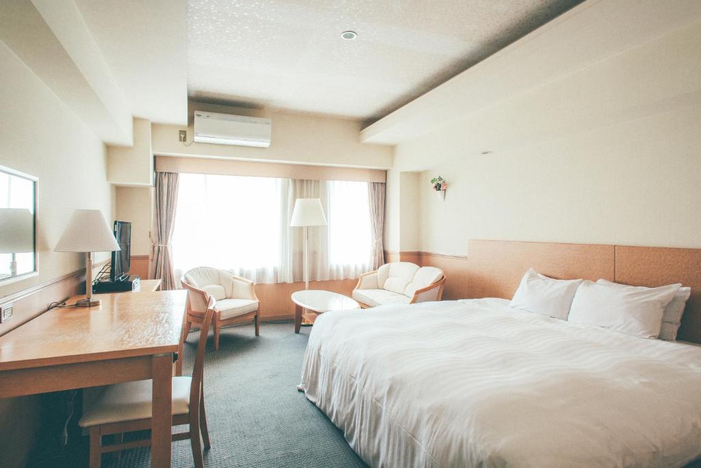 a hotel room with a bed and a desk at Kanazawa Kokusai Hotel in Kanazawa