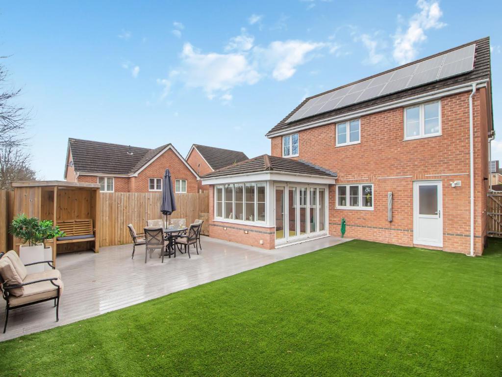 a backyard with a lawn and a house at Chestnut House in Bridgend
