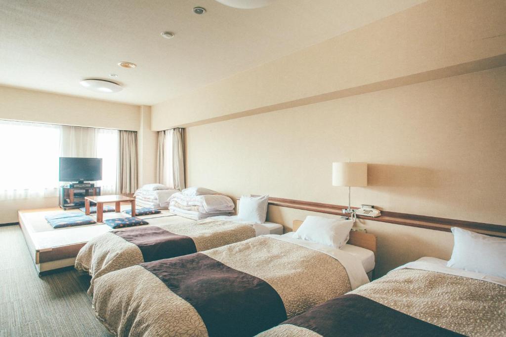 Postel nebo postele na pokoji v ubytování Kanazawa Kokusai Hotel