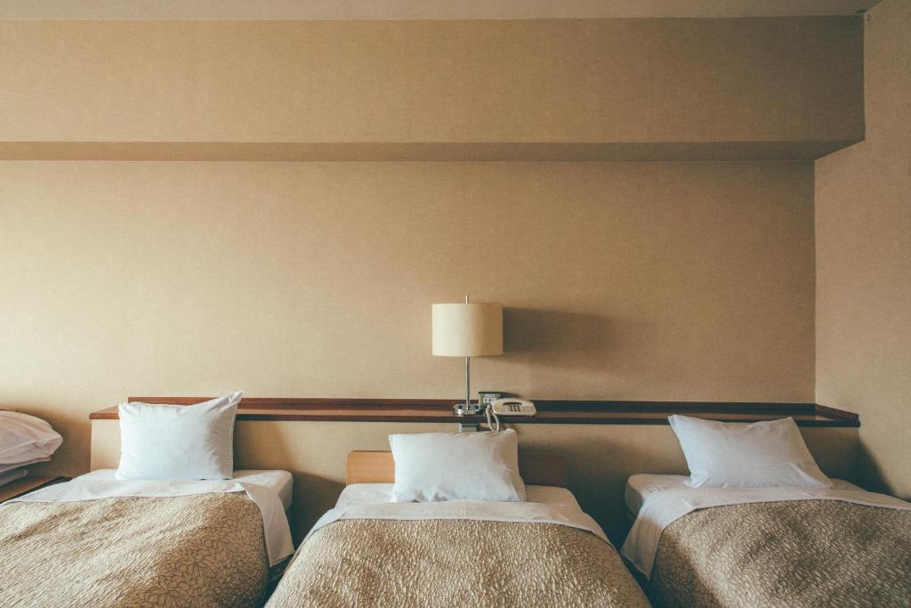 Postel nebo postele na pokoji v ubytování Kanazawa Kokusai Hotel