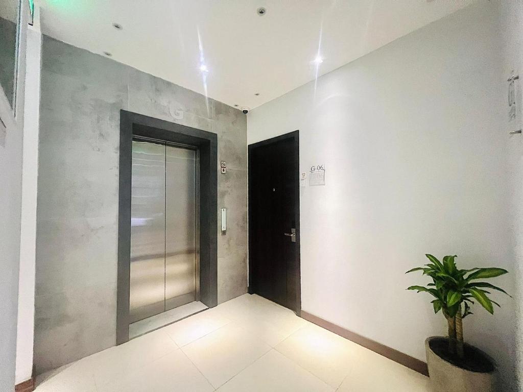 un corridoio con una porta e una pianta in vaso di oxy suites 1-03 at Shop House Meisterstadt Pollux Habibie a Batam Center