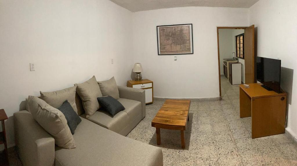 a living room with a couch and a tv at Beds Friends Asis in Mexico City