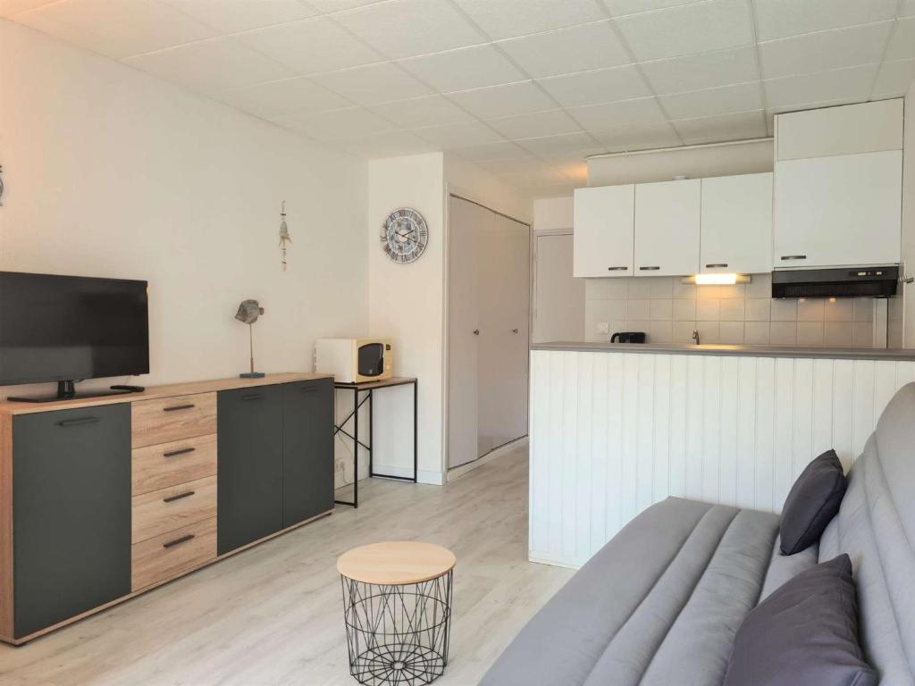 ein Wohnzimmer mit einem Sofa und einer Küche in der Unterkunft Appartement Cap d'Agde, 1 pièce, 2 personnes - FR-1-249-398 in Cap d'Agde