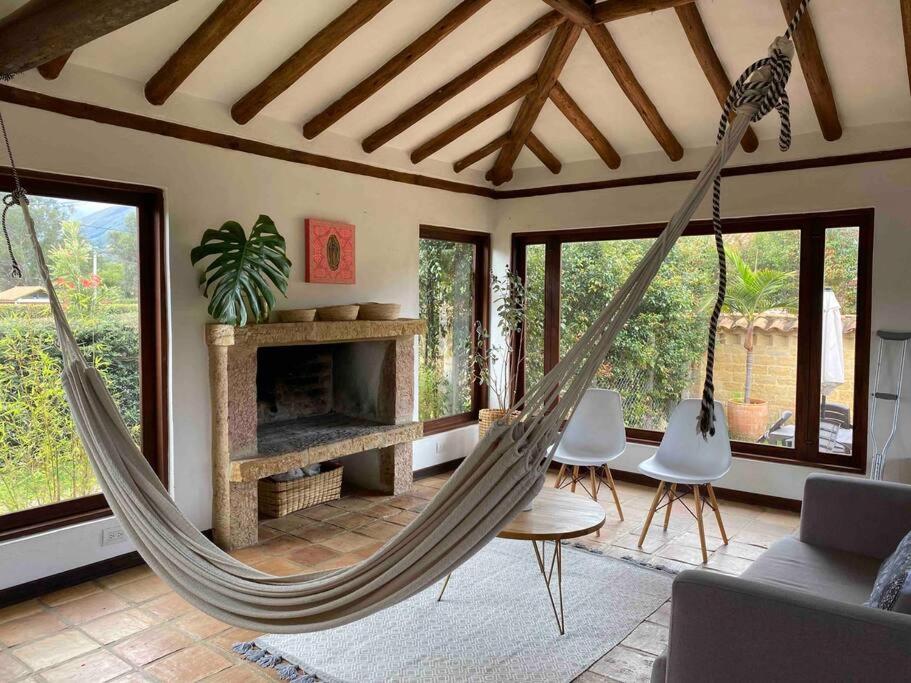 a swinging hammock in a living room with a fireplace at CASAMIGOS in Villa de Leyva