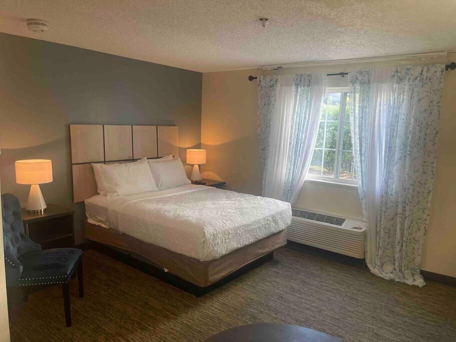 a bedroom with a bed and a window and a chair at Ultimate Escape/Free Parking in Houston
