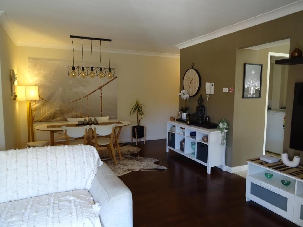a living room with a white couch and a table at Sunny 2 bed Restaurants beach at door Pets O.K in Sydney