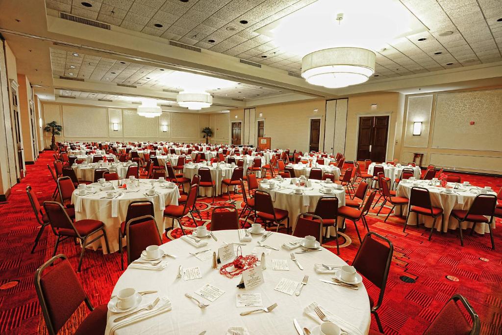 un salón de banquetes con mesas y sillas blancas en Mobile Marriott, en Mobile