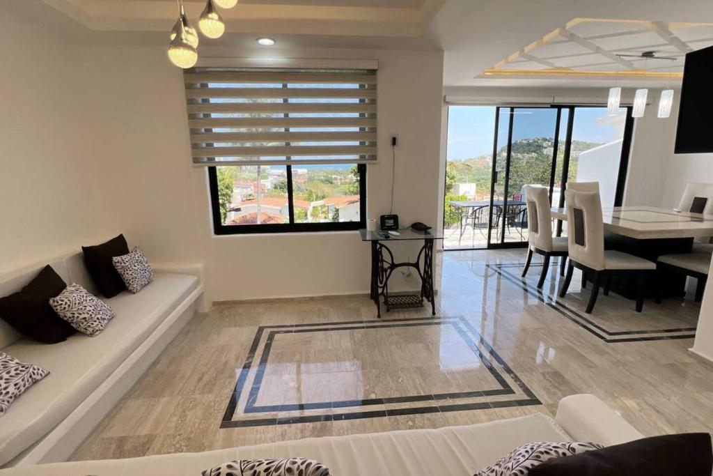 uma sala de estar com um sofá e uma mesa de jantar em Villa Malaga Acapulco, Gro em Acapulco