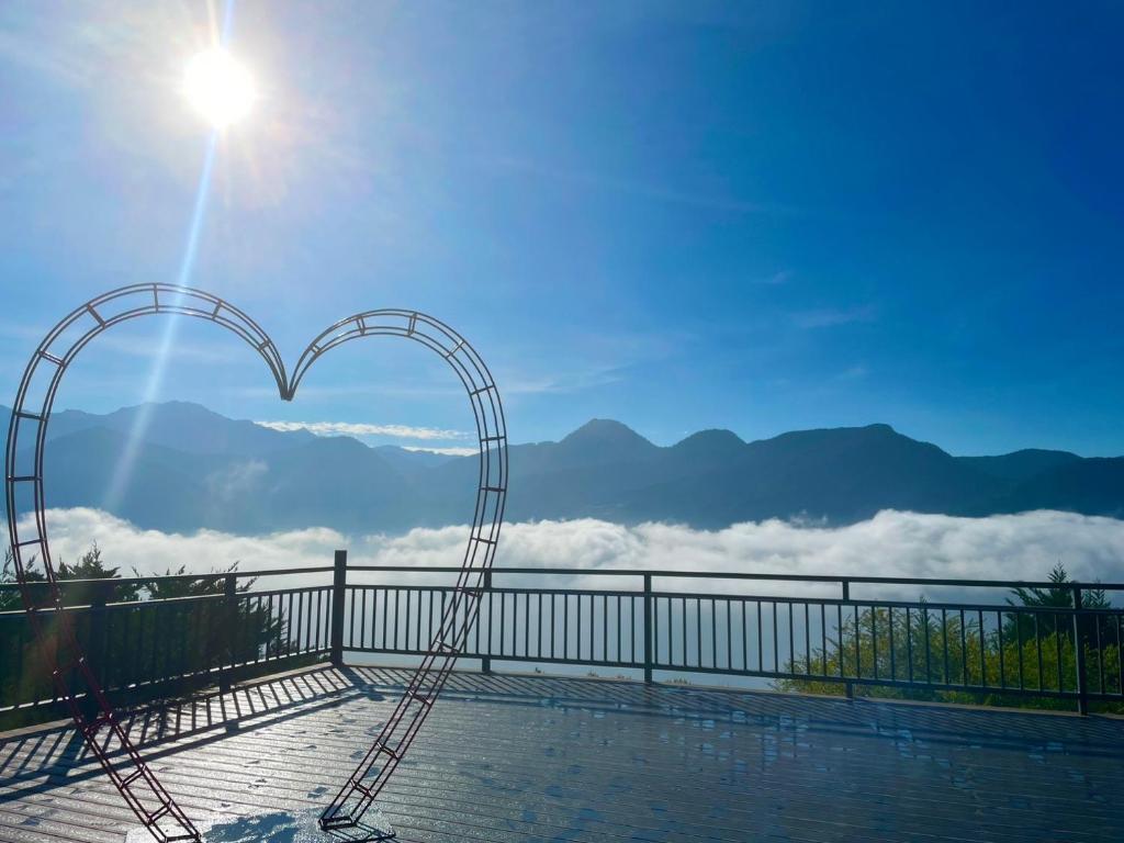 a metal heart arch with a view of the mountains at Julie&#39;s Garden, Cingjing - Fon Chin Homestay in Ren&#39;ai