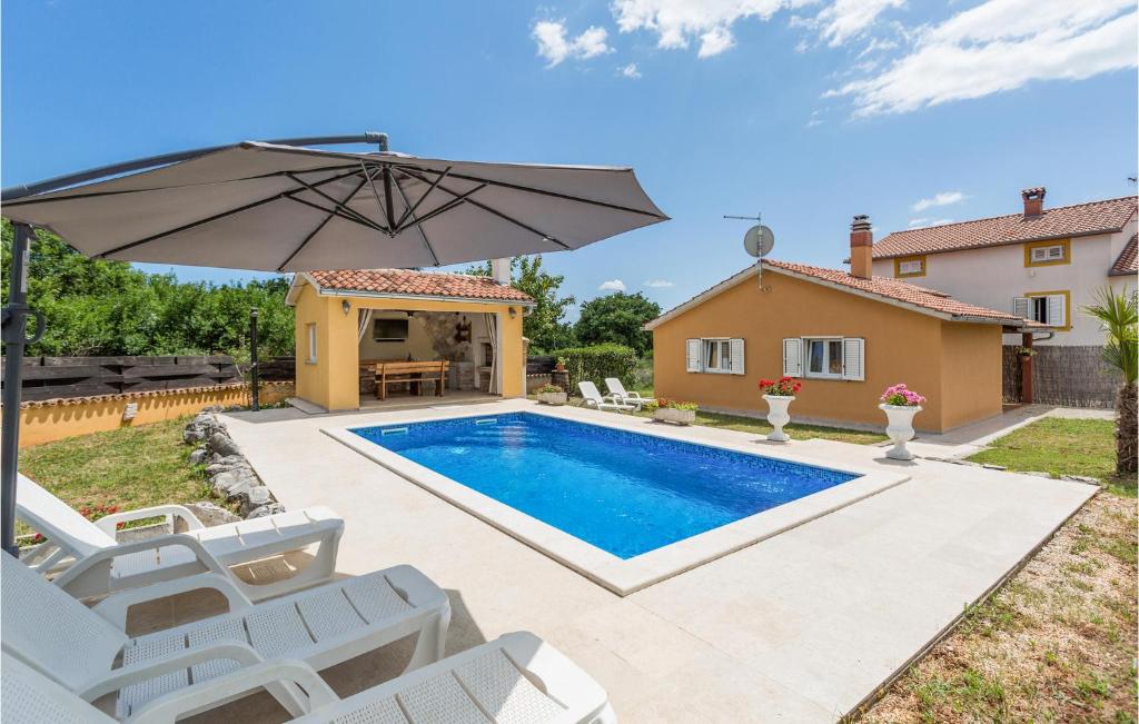 a pool with an umbrella and chairs and a house at Awesome Home In Sv,petar U Sumi With Kitchen in Sveti Petar u Šumi