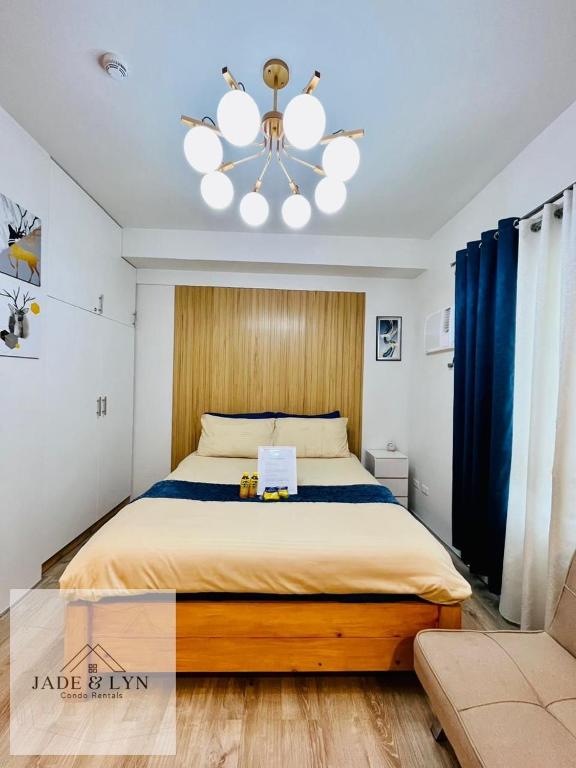 - une chambre avec un grand lit et un lustre dans l'établissement Your home away from home, at the heart of Bacolod., à Bacolod