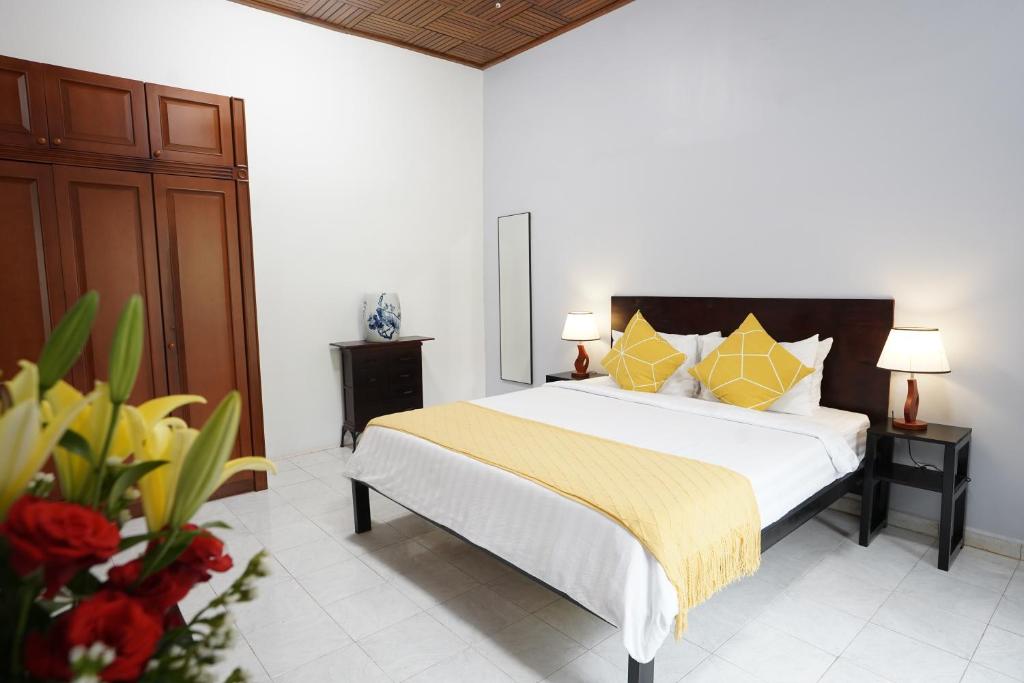 a bedroom with a large bed with yellow pillows at Birdcage Boutique in Phnom Penh