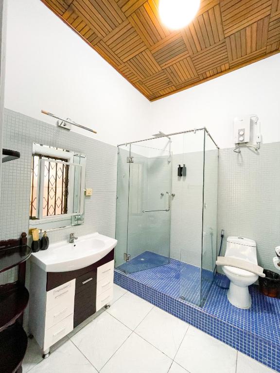 a bathroom with a shower and a sink and a toilet at Birdcage Boutique in Phnom Penh
