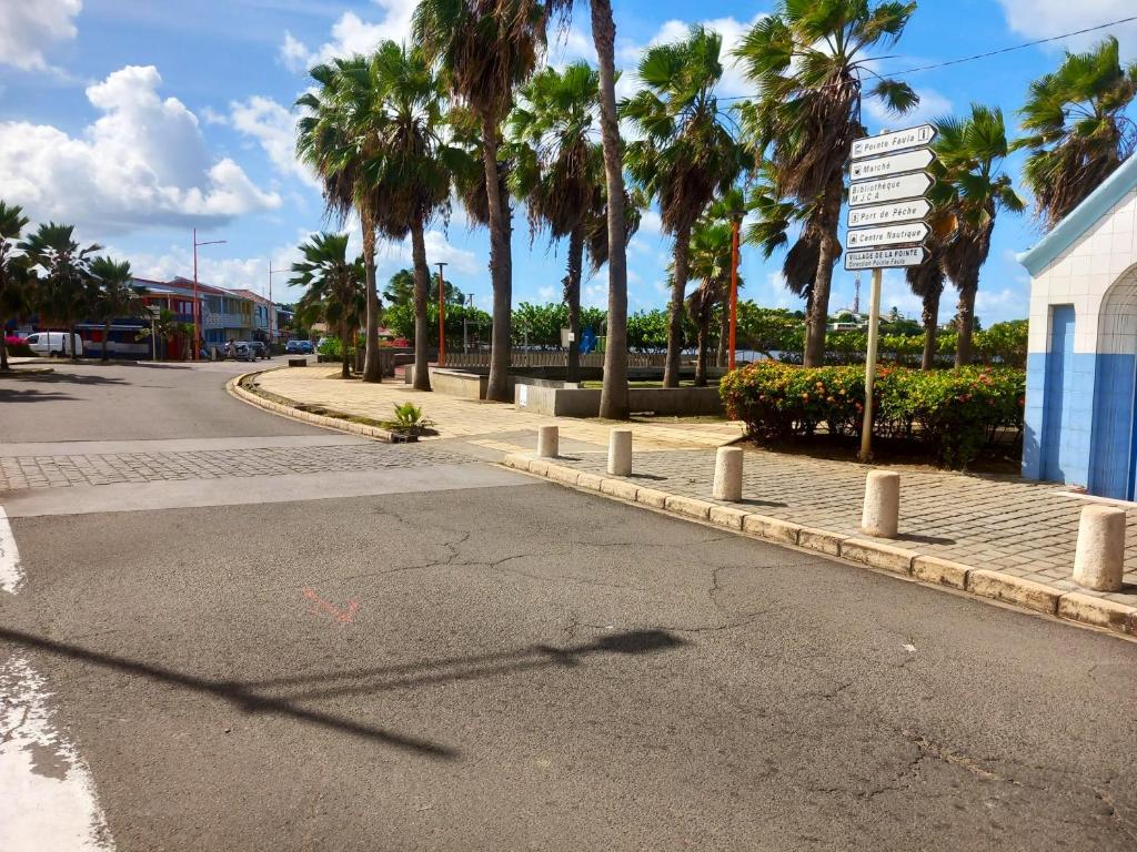 an empty street with palm trees and a street sign at Appartement d&#39;une chambre avec balcon et wifi a Le Vauclin a 3 km de la plage in Le Vauclin