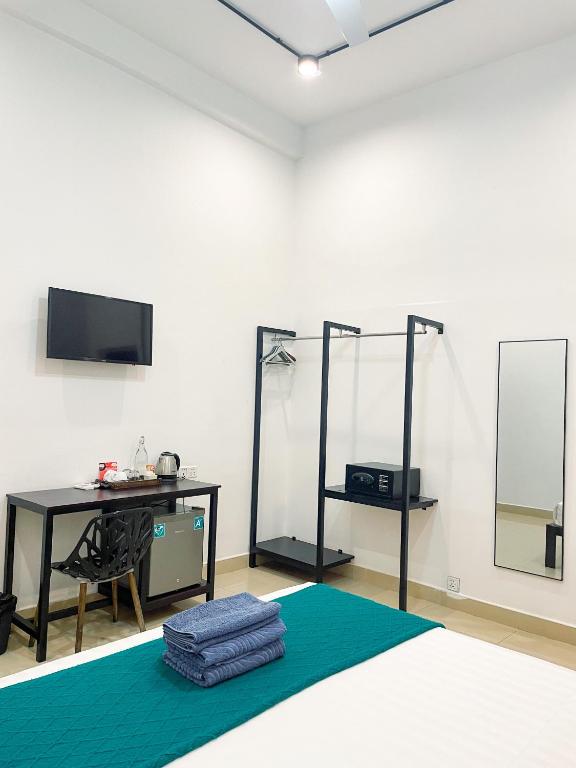 a room with a bed and a desk and a tv at Birdcage Boutique in Phnom Penh