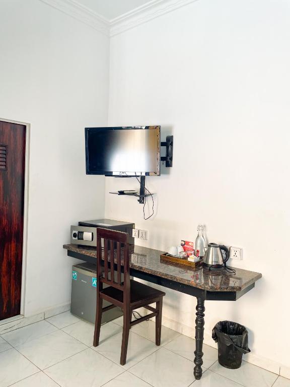 a desk with a chair and a television on a wall at Birdcage Boutique in Phnom Penh