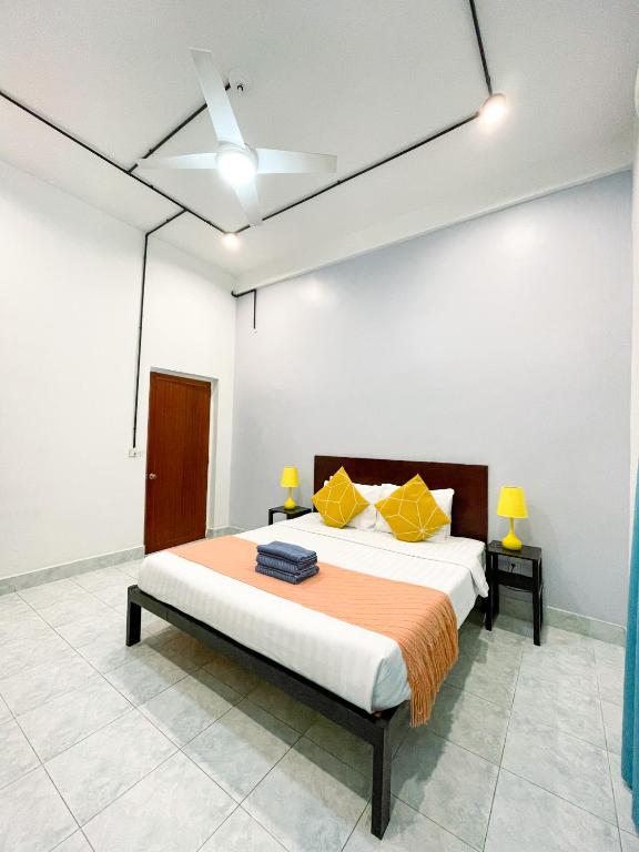 a bedroom with a bed with orange and yellow pillows at Birdcage Boutique in Phnom Penh